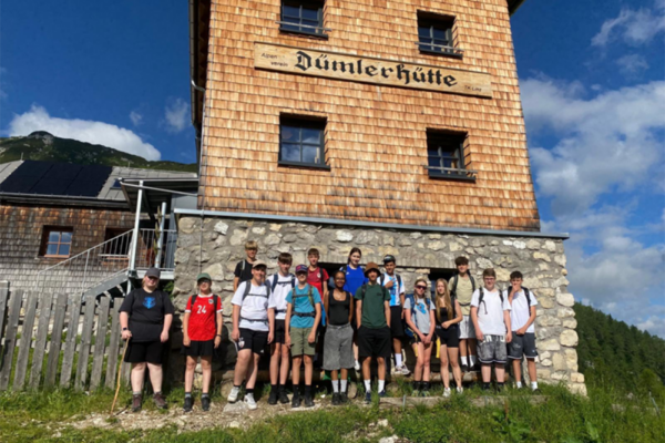 Gruppenfoto bei dem mehrere Kinder vor der Dümlerhütte stehen.